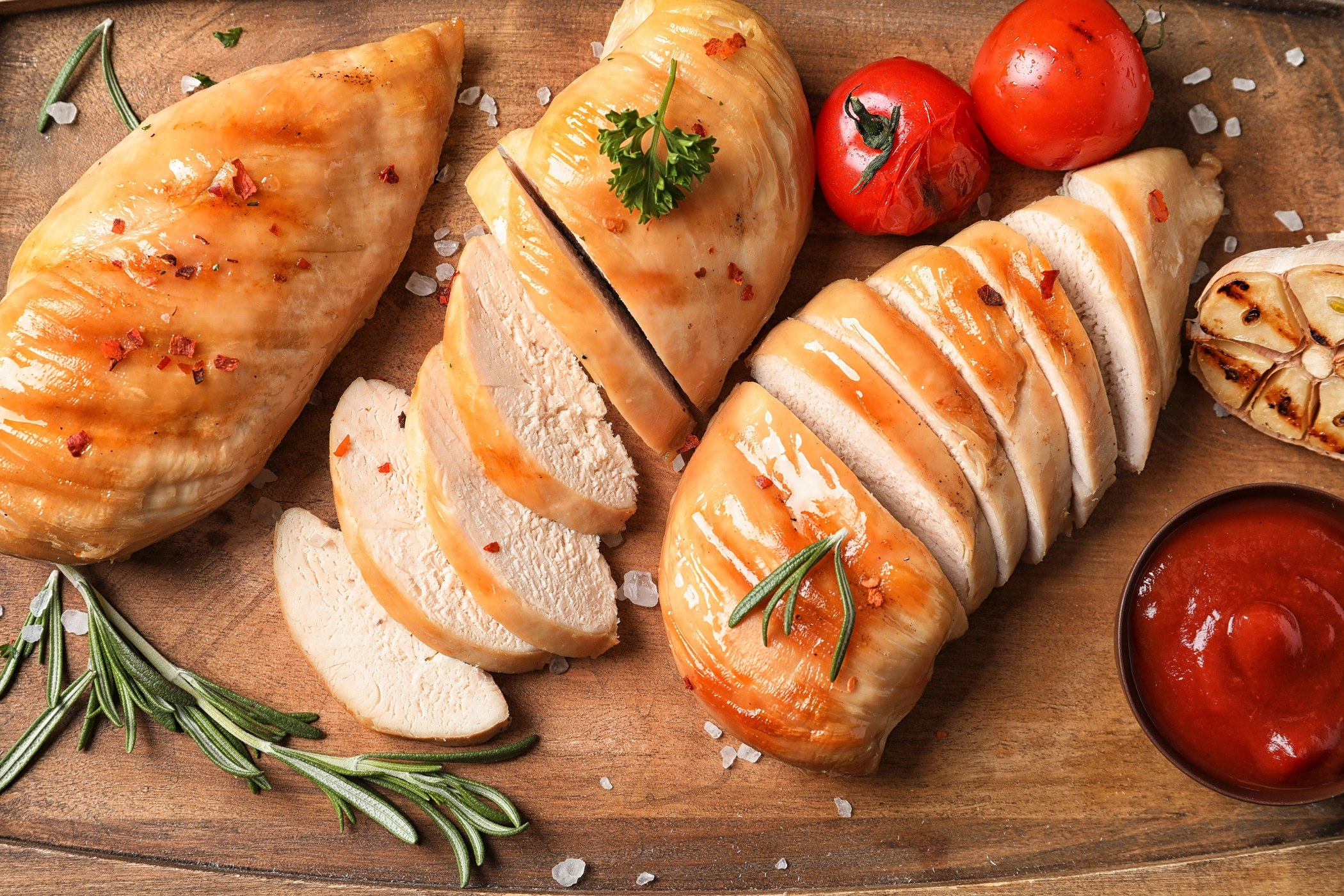 Cooked chicken breast on a cutting board