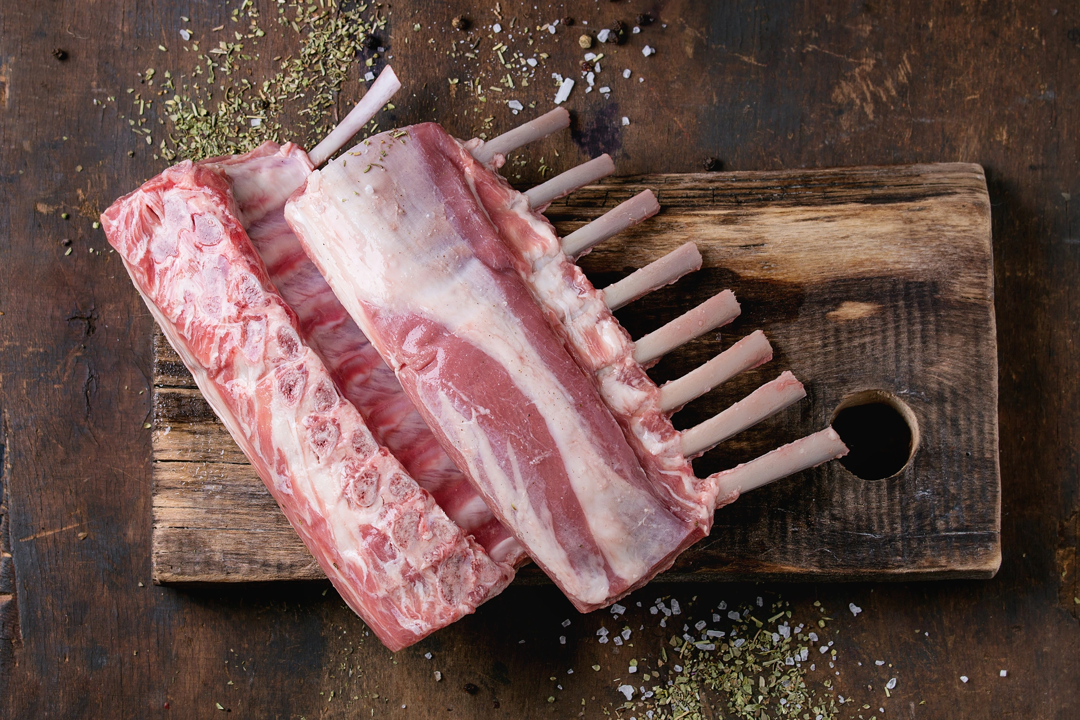 Uncooked rack of lamb on a cutting board
